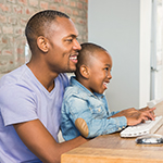 Father and son using computer.