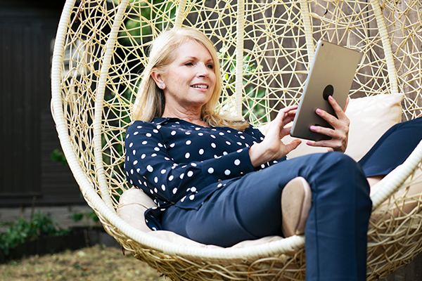 Mature woman using tablet outside