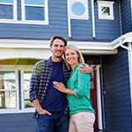 Man and Women standing in front of a house.
