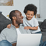 Father and son looking at laptop.