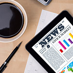 Tablet with news and coffee