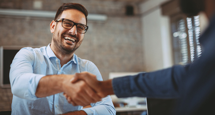 Two men shaking hands in office