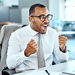 Businessman excitedly looking at his laptop in the office.
